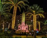 Nocna iluminacja palm i fontanny z rzeźbami. Wspaniała atmosfera, jakby trwały święta w Hiszpanii.