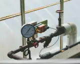 Manometr wskazuje niskie jakie ciśnienie na piecu gazowym. Rury i zawory w systemie grzewczym.