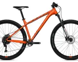 Pomarańczowy rower górski z amortyzowanym widelcem. Czy to hardtail czy full? Ten model to klasyczny hardtail, gotowy na wyzwania.