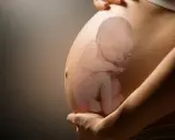 Pancia di donna incinta con immagine sovrapposta di un feto in posizione podalica, con le gambe rivolte verso il basso.