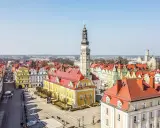 Rynek w Bolesławcu z ratuszem i wieżą zegarową. Kolorowe kamienice i brukowany plac tworzą urokliwe bolesławiec atrakcje.