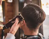 Stylista pokazuje, jak obciąć włosy maszynką, tworząc modne cięcie.