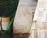 Kubek z kawy z papieru, torba na zakupy z eko papieru i otwarte książki.