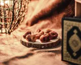Datteln und ein Koran symbolisieren das Ende des Ramadan. So feiert man warum feiert man zuckerfest.