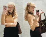 Sandra Beijer blogg: En kvinna med glasögon och ljusblont hår tar en selfie med sin telefon. Hon bär en orange tröja, mörk kjol och en brun väska.