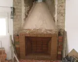 Construcción de chimenea de obra. El hogar de ladrillo y la campana cónica de cemento están en proceso. Aprende como hacer una chimenea de obra que no haga humo.