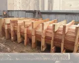 Encofrados de madera apilados, listos para dar forma a grandes estructuras circulares.