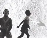 Bambini in corsa su uno sfondo bianco, un'istantanea di Piergiorgio Branzì che cattura la vitalità.