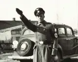 En man i uniform med hakkors hälsar. Bilden visar svenska nazister.
