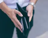 Puste ręce trzymające portfel, symbolizujące trudności finansowe i przykłady stagflacji.