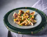 Gyoza vegetarisch, appetitlich mit würziger Soße und Frühlingszwiebeln garniert, auf einem Teller in einem grünen Bambuskorb serviert.