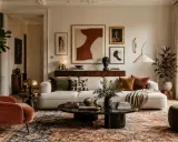 Przytulny salon w stylu naturalnym. Miękka sofa, aksamitny fotel i bogaty dywan tworzą ciepłą atmosferę.