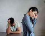 Pareja con expresiones de desánimo, uno con la mano en la cabeza, el otro pensativo. Un reflejo del refuerzo intermitente en la pareja.