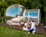 Coppia brinda con vino rosso davanti a bolle trasparenti, un'esperienza unica tra i posti romantici Italia.