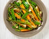 Jardinière de légumes colorée : carottes, pois, asperges et fenouil grillés, garnie de thym frais. Un plat sain et appétissant.