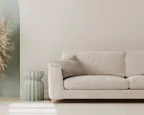 Jasny, przytulny salon z beżową kanapą i dekoracyjną trawą. Idealny pomysł na pustą ścianę w salonie, dodający lekkości i stylu.