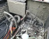 Wnętrze komputera pokryte grubą warstwą kurzu i pajęczyn. Widać płytę główną, kable i wentylator, które wymagają pilnego czyszczenia komputera.