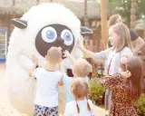 Dzieci bawią się z pluszową owcą, szukając pomysłu, gdzie na weekend z niemowlakiem.