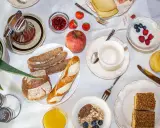 Un ricco e genuino **colazione contadina** con pane integrale, marmellata, frutta fresca, yogurt, succo d'arancia e dolcetti.