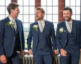 Three groomsmen in navy suits with floral ties and boutonnieres, ready for the usher wedding.