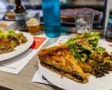 Tranche de pâté en croûte, spécialité Limoges, servie avec salade et pommes de terre rôties.