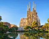 La Sagrada Familia, simbolo di **attività Barcellona**, si specchia in un laghetto circondato da verde.