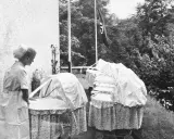Pielęgniarka przy wózkach dziecięcych. Flaga nazistowska w tle. To obrazek z czasów Lebensborn, co to za program?