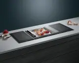 Moderner Kochfeld mit integriertem Grill, ideal für die Zubereitung von Fisch. Die breite Kochfläche bietet viel Platz.