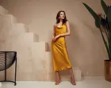 Elegancka, żółta sukienka na ramiączkach pięknie układa się na modelce. Dowiedz się, co zrobić, żeby sukienka się nie elektryzowała.