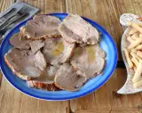 Plato azul con lonchas de jugosa carne mechada, servida con palitos de pan crujientes al lado.