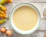Pastella per fiori di zucca pronta in ciotola, con fiori freschi e uova a lato.