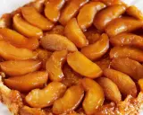 En gyllene tarte tatin med karamelliserade äppelklyftor som glänser. En klassisk fransk dessert som smälter i munnen.