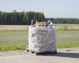 Stor säck med huggen ved på pall, redo för vinterkylan.