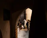 Ślub w kościele, para młoda i goście. Początkujący fotograf uchwycił ten magiczny moment zza ciemnego przejścia.