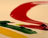 Kolory farb akrylowych: czerwony, zielony i żółty, tworzą dynamiczne pociągnięcia pędzla. Pokazuje to, jak mieszać kolory farb akrylowych.