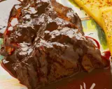Succulento stracotto di manzo in salsa scura, servito con polenta dorata. Un classico della ricetta dello stracotto.