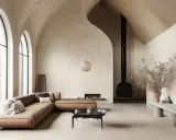 Un vaste salon cathédrale aux voûtes élancées, avec un canapé en cuir cognac, une cheminée moderne et une lumière douce.