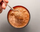 Ein Löffel mit Schokostückchen auf einer cremigen Mousse au Chocolat. Das Originalrezept für puren Genuss.