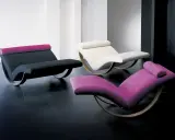 Trzy nowoczesne szezlongi: czarny z różową poduszką, biały i fioletowy. Idealne do relaksu.