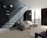 Escalera moderna de cristal con peldaños blancos y barandilla de vidrio en un salón luminoso.