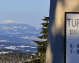 Zimowy krajobraz z Turbacza, szczytu o wysokości 1310 m n.p.m. Śnieg pokrywa okoliczne góry i lasy.