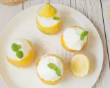 Délicieux citron givré, des citrons évidés remplis de sorbet et décorés de menthe fraîche. Un dessert rafraîchissant et visuellement attrayant.