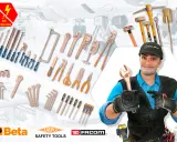 Un trabajador sonriente muestra herramientas de bronce, incluyendo llaves inglesas y alicates, junto a un surtido de herramientas de seguridad.