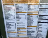 Menu McDonald's z ofertą promocyjną i klasyczną. Widoczne są ceny i nazwy produktów, np. McWrap, McRoyal, Lody z polewą mango-marakaja. Opłata reklamowa jest tu widoczna w postaci prezentacji oferty.