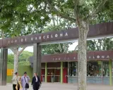 Eingang zum Zoo de Barcelona mit drei Frauen, die davor spazieren gehen.