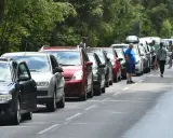 Długi korek samochodów na trasie do Helu. Kierowcy stoją w upale, czekając na przejazd.