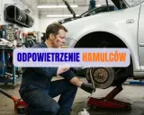Mechanik odpowietrza hamulce z ABS w warsztacie, dbając o bezpieczeństwo na drodze.