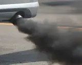 El tubo de escape de un coche emite una densa nube de humo negro al acelerar, contaminando el aire.