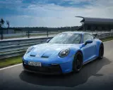 Ein blauer Porsche GT3 Rennwagen rast auf einer Rennstrecke.