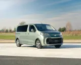 Nowy, zielony minivan Toyota Proace Verso na tle nieba i pól. Idealny na rodzinne wycieczki.